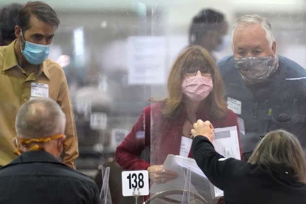 Recount observers check ballots on Nov. 20, 2020, during a Milwaukee hand-recount of presidential votes. A narrowly divided Wisconsin Supreme Court later rejected Donald Trump's lawsuit attempting to overturn his loss to Democrat Joe Biden about an hour before the Electoral College was to meet to cast the state's 10 votes for Biden. (Photo: Nam Y. Huh/Associated Press)