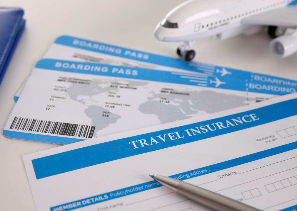 Close-up of airline tickets and empty travel insurance form with pen.