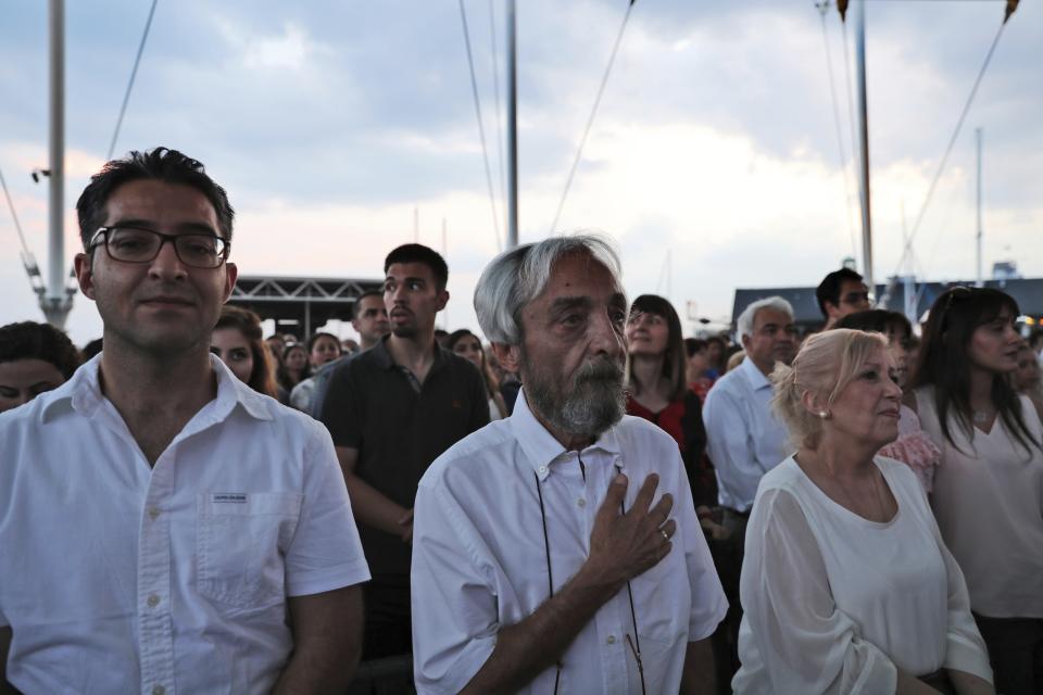 In this Thursday, July 25, 2019 photo, a man puts his hand on his heart as they broadcast "Ey Iran", an Iranian patriotic song, which many Iranians consider the unofficial de facto of their national anthem, during the opening ceremony of the Tirgan summer festival at the Harbourfront Centre in Toronto, Canada. The event aims to preserve and celebrate Iranian and Persian culture, said festival CEO Mehrdad Ariannejad. Among those who attended were second-and third-generation immigrants, many of whom have never been to Iran or have not been there since leaving the country following the 1979 Islamic Revolution. (AP Photo/Kamran Jebreili)