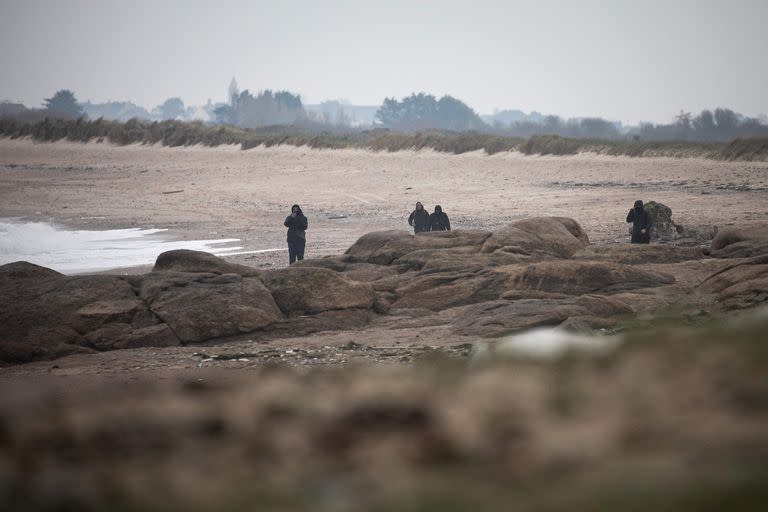 Civiles buscan bolsas con cocaína en las playas de Neville sur Mer, en Francia. (Lou BENOIST / AFP)