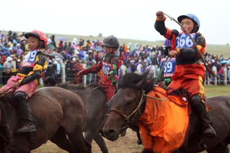 Child jockeys riding horses arrive to the finish line during a horse race at the Mongolian traditional Naadam festival, on the outskirts of Ulaanbaatar, Mongolia July 11, 2018. Picture taken July 11, 2018. REUTERS/B. Rentsendorj