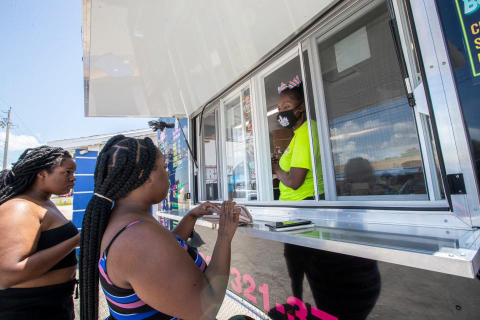 Jodora helps customers Thursday afternoon. Jodora Houston-Pender with her nephews, Jeremiah Livingston and Tyreese Houston work hard to make her food truck Sweet Drips successful. They serve, Philly Style Water Ice, Ice Cream, Churros, Philly Cheesesteaks and Donuts. 