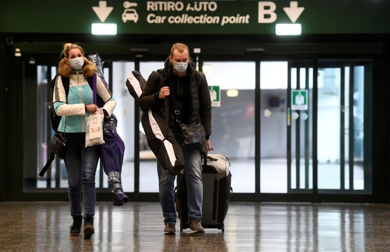 FOTO DE ARCHIVO: Personas con mascarillas protectoras en el aeropuerto de Malpensa cerca de Milán