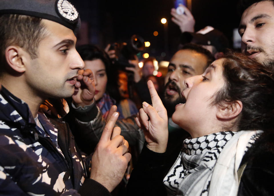 An anti-government protester, right, argues with a police officer, as protesters blocking a main road during ongoing protests against the ruling elite of corruption and financial crisis, in Beirut, Lebanon, Monday, Jan. 13, 2020. Lebanon is facing its worst economic crisis in decades, while protests against corruption and mismanagement have gripped the country since October. (AP Photo/Hussein Malla)