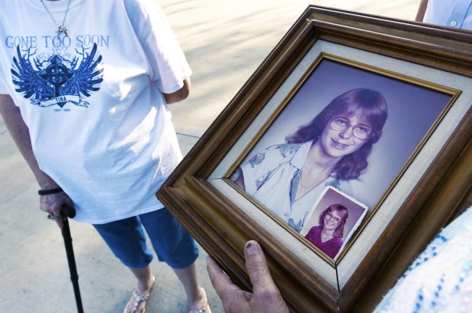 In this 2017 file photo, family members hold a portrait of Tina Lovett prior to her remains being exhumed and then reburied. Her family was not told they did not receive all of her remains following her 1984 murder near her Jacksonville, FL home. Instead, her remains were shuffled between two universities a medical examiner’s office. Her family has sued.