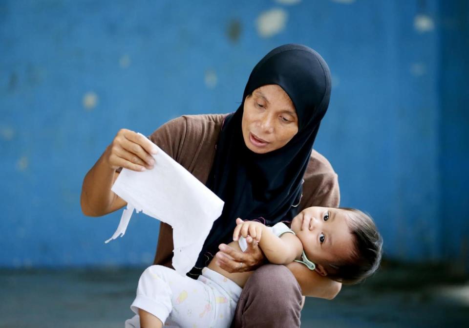A Filipino Muslim mother cuddles her baby as she checks her name and polling precinct a day before the country’s presidential elections at the front-running presidential candidate Rodrigo Duterte’s hometown of Davao city in southern Philippines, May 8, 2016, Philippines. Millions of voters are expected to troop to polling precinct all over the country to elect the successor of President Benigno Aquino III. (Bullit Marquez/AP)
