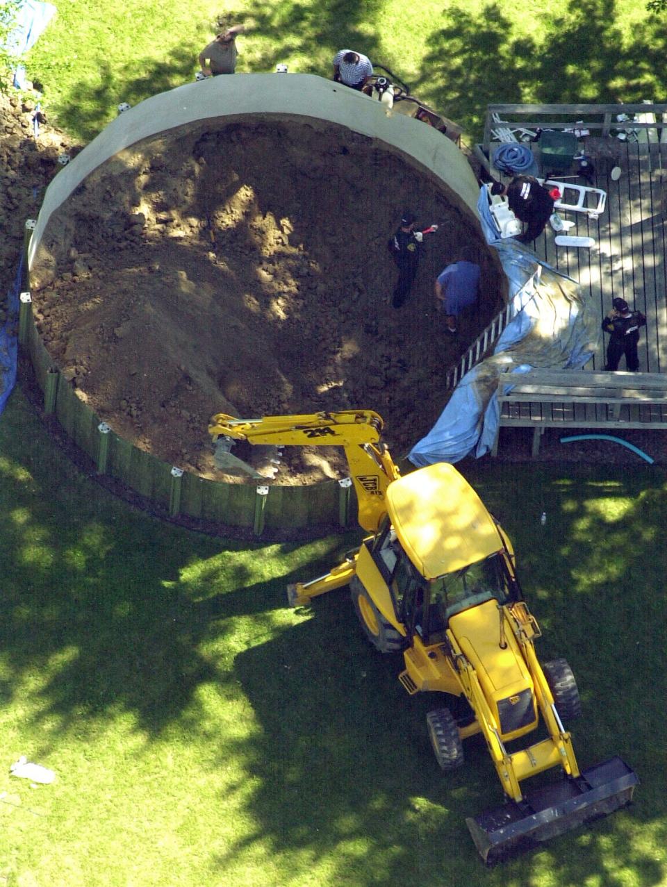 In this July 16, 2003 file photo, authorities search under a backyard pool in Hampton Township, Mich., for evidence linked to the disappearance of ex-teamster boss Jimmy Hoffa. The search turned up nothing. The FBI has seen enough merit in a reputed Mafia captain's tip to once again break out the digging equipment to search for the remains of Hoffa, last seen alive before a lunch meeting with two mobsters nearly 40 years ago. Tony Zerilli told his lawyer that Hoffa was buried beneath a concrete slab in a barn in a field in suburban Detroit in 1975.