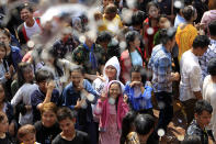 Cambodian garment workers get the holy water to mark the end of the Khmer New Year on the outskirts of Phnom Penh, Cambodia, Sunday, April 21, 2019. Buddhist followers received the holly water which is believed to bring good luck. (AP Photo/Heng Sinith)