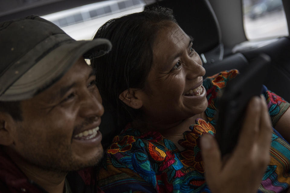 Mynor Cardona and Ufemia Tomas, parents of Yenifer Yulisa Cardona Tomás, smile as they talk with her through a call to the hospital where she is being treated in Guatemala City, Monday, July 4, 2022. Yenifer Yulisa Cardona Tomás is one of the survivors of the more than 50 migrants who were found dead inside a tractor-trailer near San Antonio, Texas. (AP Photo/Oliver de Ros)