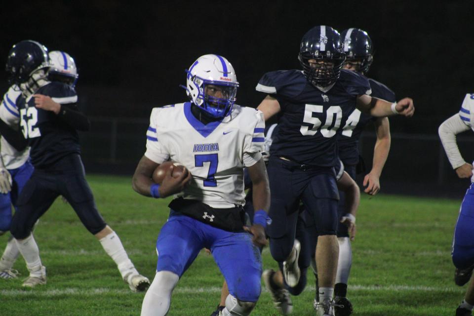 Ionia senior quarterback Travis Tucker Jr. (No. 7) carries the ball while Lake Odessa Lakewood senior Samuel Mazurek (No. 50) chases him during a varsity football game Friday, Oct. 20, at Lakewood Unity Field. Ionia won the game, 20-0.