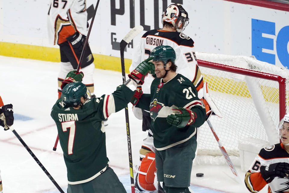 Minnesota Wild's Brandon Duhaime (21) is congratulated by Nico Sturm after Duhaime scored against Anaheim Ducks' goalie John Gibson during the first period of an NHL hockey game Saturday, Oct. 23, 2021, in St. Paul, Minn. (AP Photo/Jim Mone)