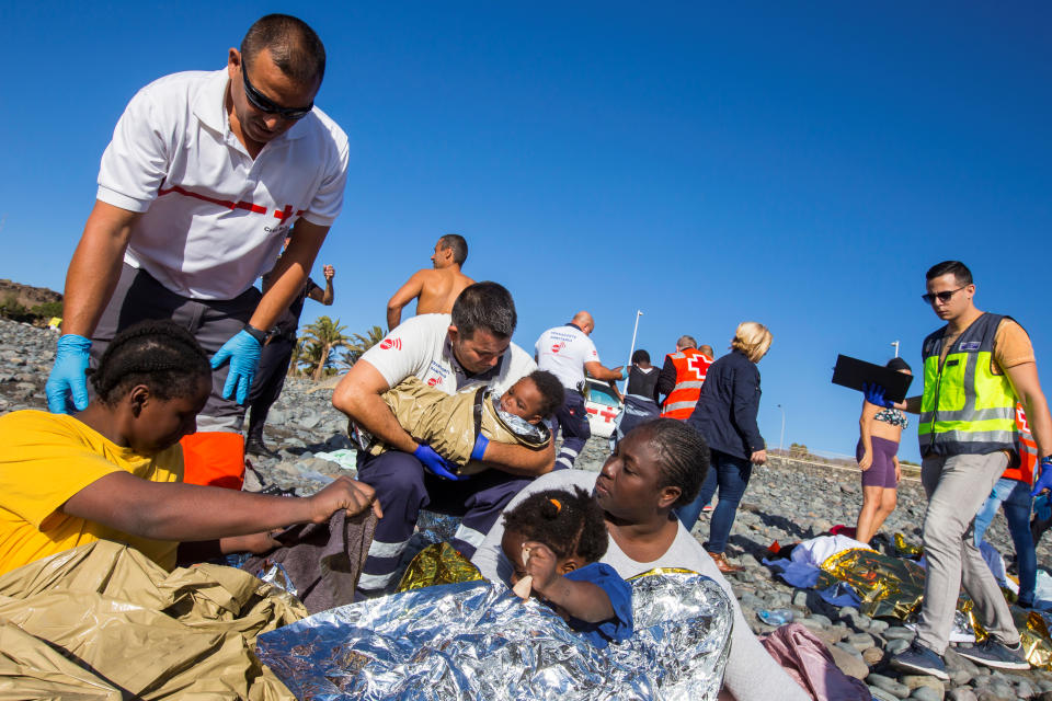 Rescue service members attend to migrants.