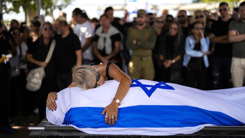 Antonio Macías’ mother cries over her son’s body covered with the Israeli flag at Pardes Haim cemetery in Kfar Saba, near Tel Aviv, Israel, on Sunday, Oct. 15, 2023. Macias was killed by Hamas militants while attending a music festival in southern Israel earlier this month. The Israeli public is in a state of shock a week after Hamas militants launched an unprecedented attack on Israel, killing scores of Israelis in border communities and kidnapping roughly 150 civilians.