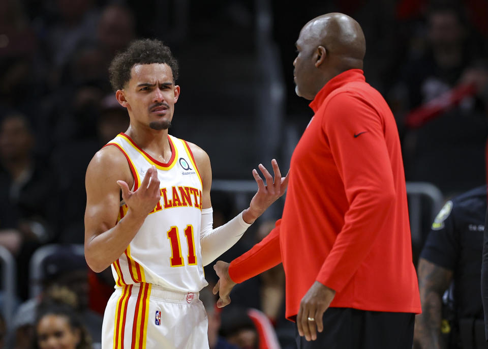 Trae Young speaks with head Coach Nate McMillan