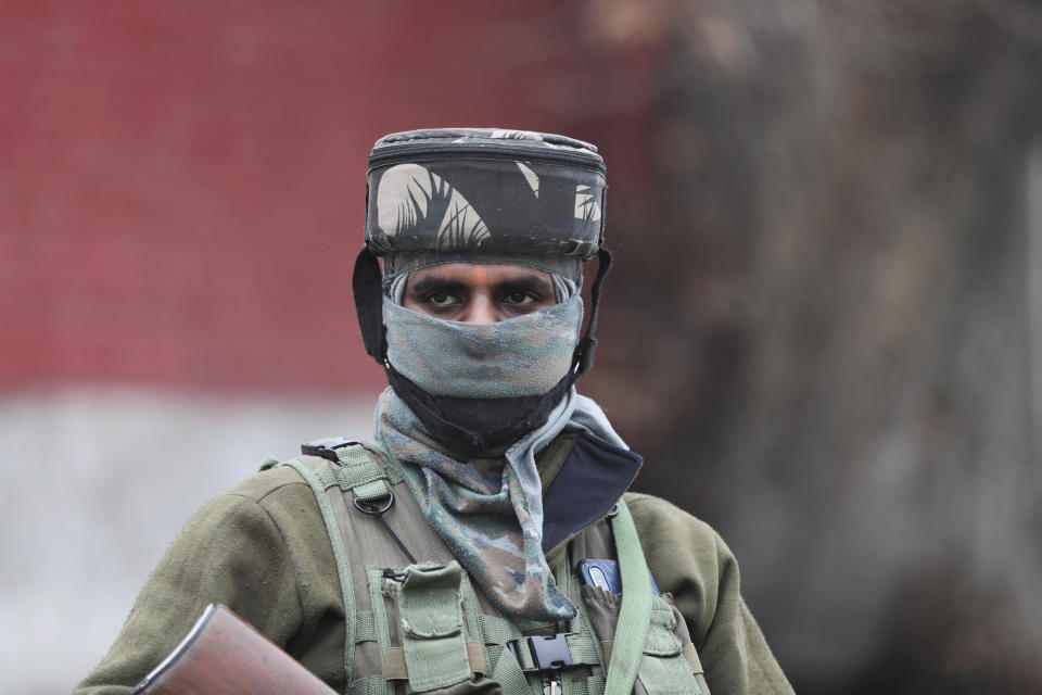 An Indian paramilitary soldier guards as a convoy of New Delhi-based diplomats passes through Srinagar, Indian controlled Kashmir, Thursday, Jan. 9, 2020. Envoys from 15 countries including the United States are visiting Indian-controlled Kashmir starting Thursday for two days, the first by New Delhi-based diplomats since India stripped the region of its semi-autonomous status and imposed a harsh crackdown in early August. (AP Photo/Mukhtar Khan)