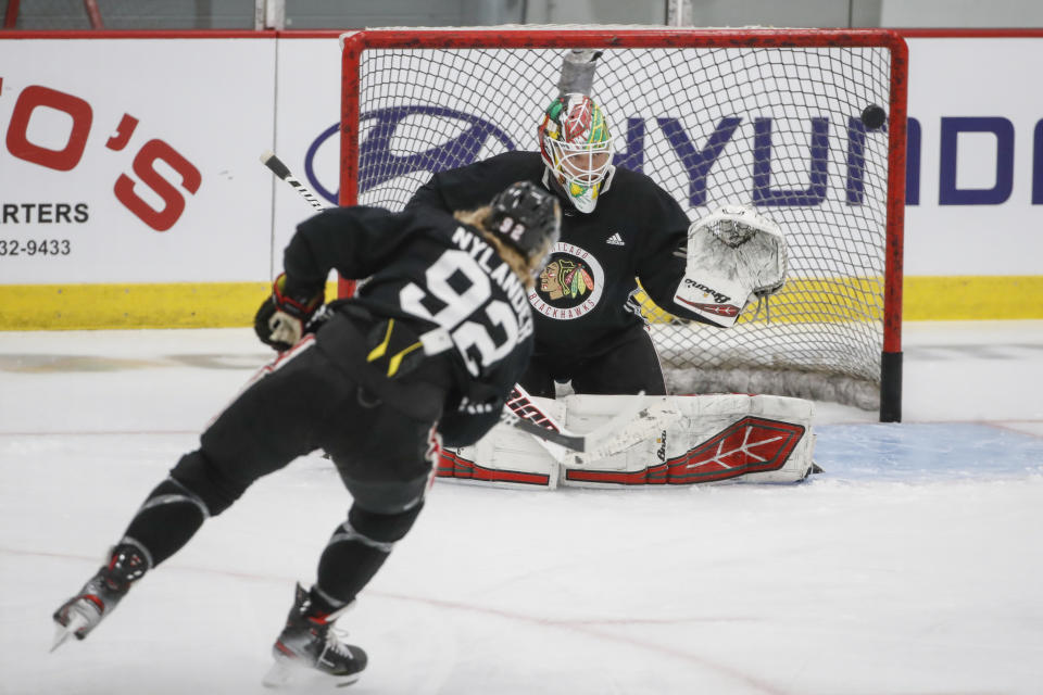 Chicago Blackhawks goaltender Collin Delia defends against left wing Alex Nylander during NHL hockey practice at Fifth Third Arena on Monday, July 13, 2020, in Chicago. (AP Photo/Kamil Krzaczynski)