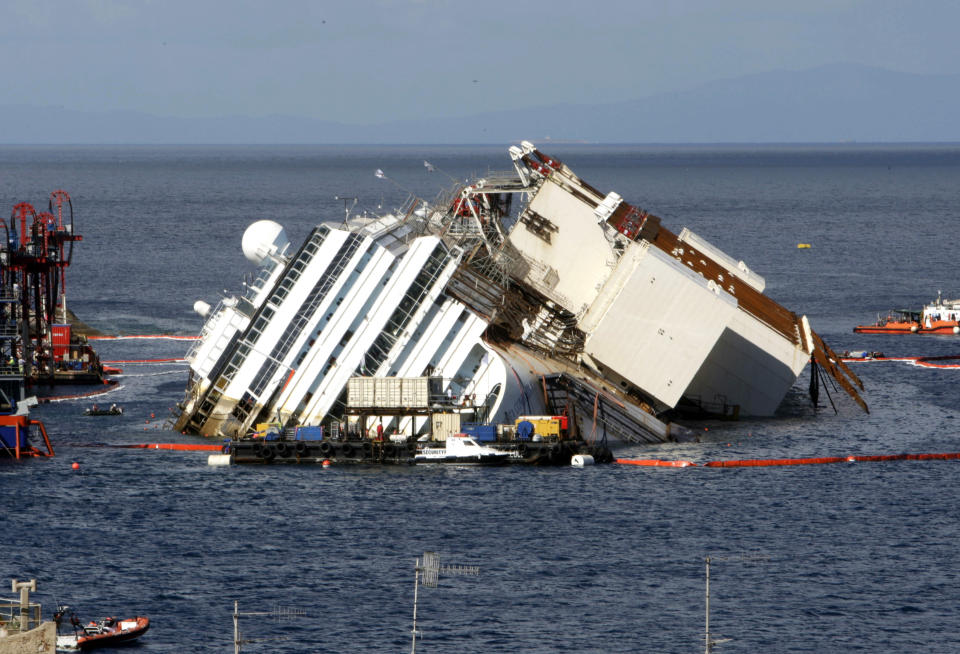FILE -- In this Sept. 16, 2013 file photo, the Costa Concordia ship as it lies on its side on the Tuscan Island of Giglio, Italy. One of the tanks fastened to the shipwrecked Costa Concordia cruise liner to help prepare it for removal to land has shifted, Tuesday, may 6, 2014. The consortium overseeing the operation said in a statement that the cause was under investigation and that there was no damage to the ship. Workers fastened the first tank to the starboard side of the ship last week. The tanks, 19 in all, were being filled with water to help stabilize the Concordia, now resting on an artificial seabed after it was set upright in September. (AP Photo/Andrew Medichini)
