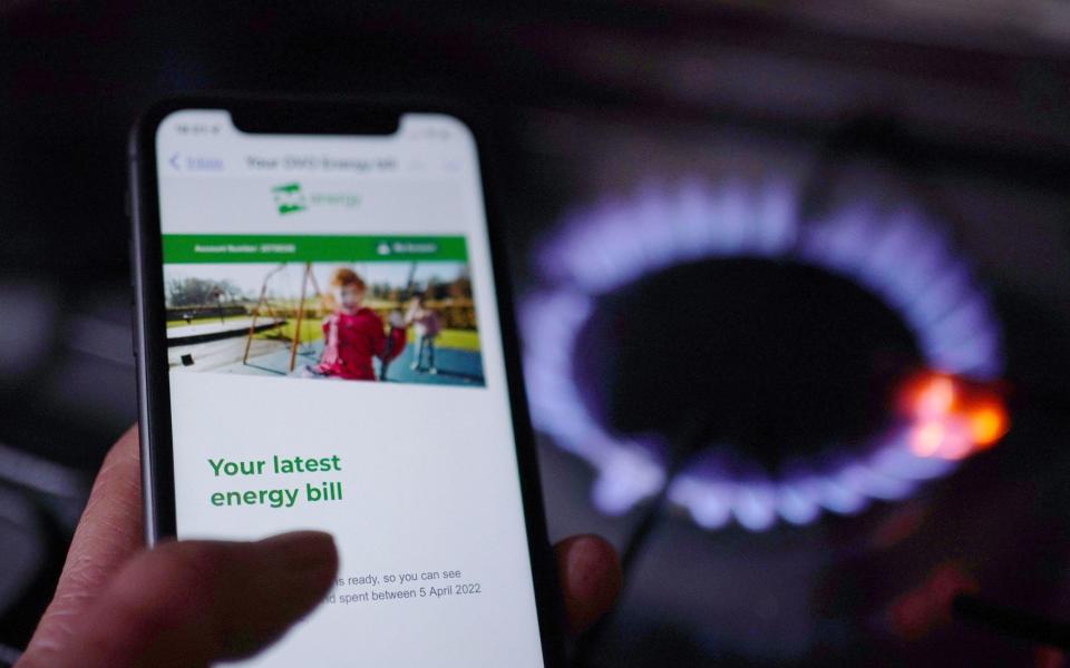 A general view of a household energy bill displayed on a mobile phone held next to a gas hob - Yui Mok/PA Wire
