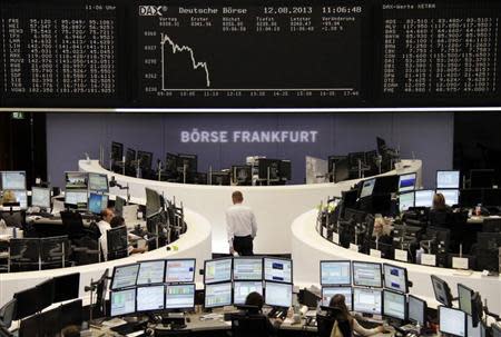 Traders are pictured at their desks in front of the DAX board at the Frankfurt stock exchange August 12, 2013. REUTERS/Remote/stringer