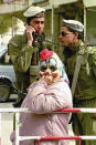 <p>A female Jewish settler dressed as a clown for the Jewish holiday of Purim stands in front of two Israeli soldiers the West Bank town of Hebron, March 7, 1993. (Photo: Jacqueline Larma/AP) </p>