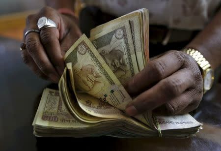 A money lender counts Indian rupee currency notes at his shop in Ahmedabad, in this May 6, 2015 file photo. REUTERS/Amit Dave/Files