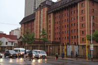 People walk outside the court building where Oscar Pistorius will arrive later for his trial in Pretoria, South Africa, Monday, March 3, 2014. Pistorius is charged with premeditated murder for the shooting death of his girlfriend, Reeva Steenkamp, on Valentine's Day in 2013. (AP Photo/Schalk van Zuydam)