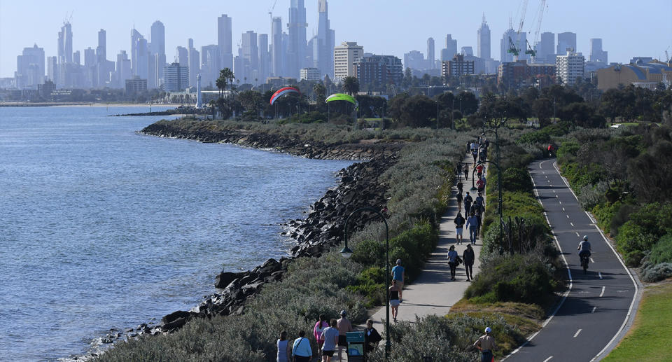 People are seen walking near the water with Melbourne's CBD in the background. Source: AAP