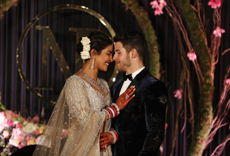 In this Tuesday, Dec. 4, 2018, file photo, Bollywood actress Priyanka Chopra and musician Nick Jonas stand for photographs at their wedding reception in New Delhi, India. (AP Photo/Altaf Qadri, File)