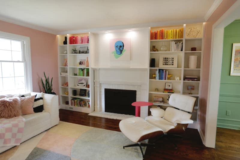 Skull painting above fireplace in pink living room.