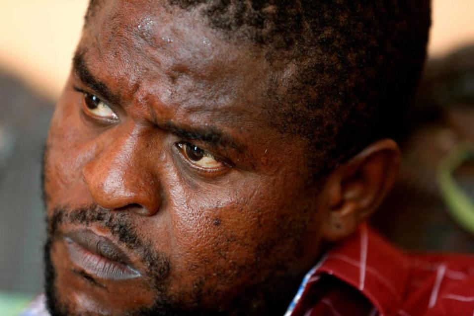 In this May 24, 2019, photo, Barbecue, whose real name is Jimmy Cherizier, sits at his house during an interview with AP, in Lower Delmas, a district of Port-au-Prince, Haiti. He’s a former policeman, a suspect in the massacre of dozens of men, women and children and a hero in his neighborhood, followed by crowds of adoring residents who consider him their protector. “I would never massacre people in the same social class as me,” Cherizier said.