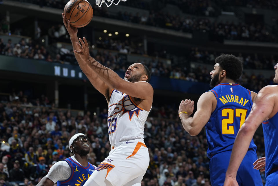 Phoenix Suns guard Eric Gordon, left, drives to the basket past Denver Nuggets guard Jamal Murray in the first half of an NBA basketball game Tuesday, March 5, 2024, in Denver. (AP Photo/David Zalubowski)