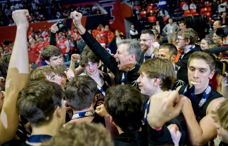 Metamora head coach Danny Grieves celebrates with the Redbirds after their 46-42 victory over Chicago Simeon in the Class 3A basketball state title game Saturday, March 11, 2023 at State Farm Center in Champaign.