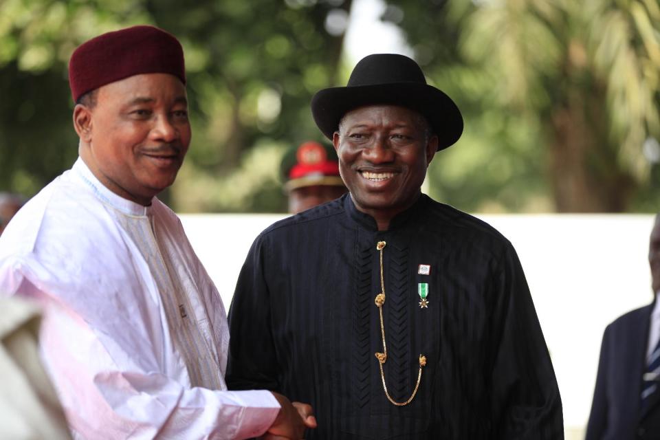 Niger's President Mahamadou Issoufou, left, and Nigeria's President Goodluck Jonathan, right, arrive for a summit to address a seminar on security during an event marking the centenary of the unification of Nigeria's north and south in Abuja, Nigeria, Thursday, Feb. 27, 2014. (AP Photo/Sunday Alamba)