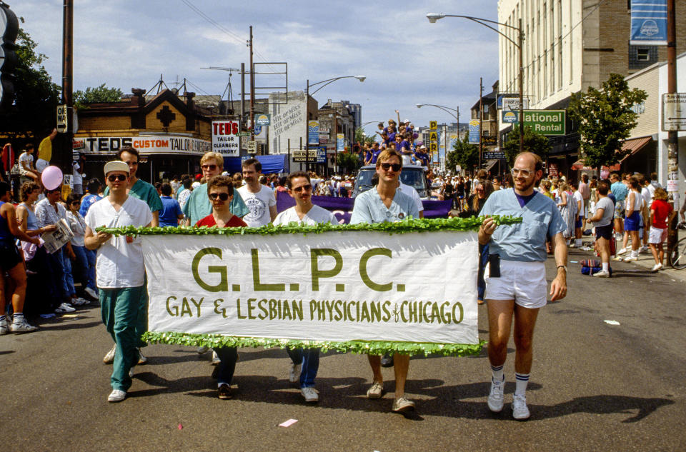 Near the intersection of North Broadway and West Barry Avenue, participants march behind a banner that reads 'G.L.P.C., Gay &amp; Lesbian Physicians of Chicago' during the annual Chicago gay and lesbian Pride day parade, Chicago, Illinois, June 28, 1987.