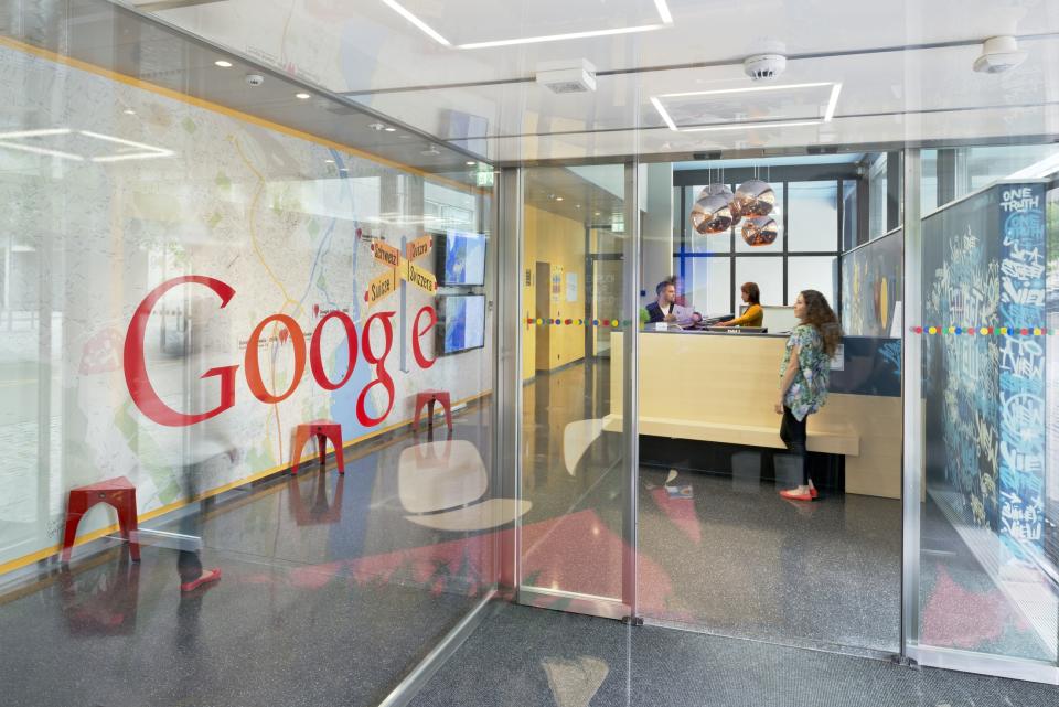 A glass wall with the Google logo near an entrance door