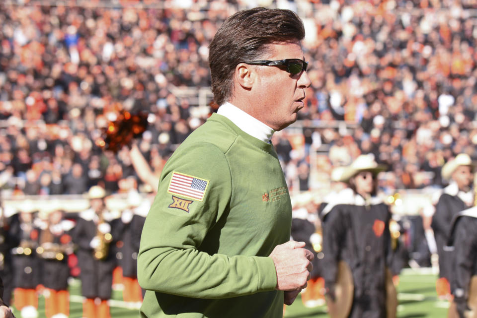 Oklahoma State head coach Mike Gundy runs onto the field prior to an NCAA college football game against Iowa State, Saturday, Nov. 12, 2022, in Stillwater, Okla. Gundy was wearing green in honor of the Military Appreciation Game. (AP Photo/Brody Schmidt)