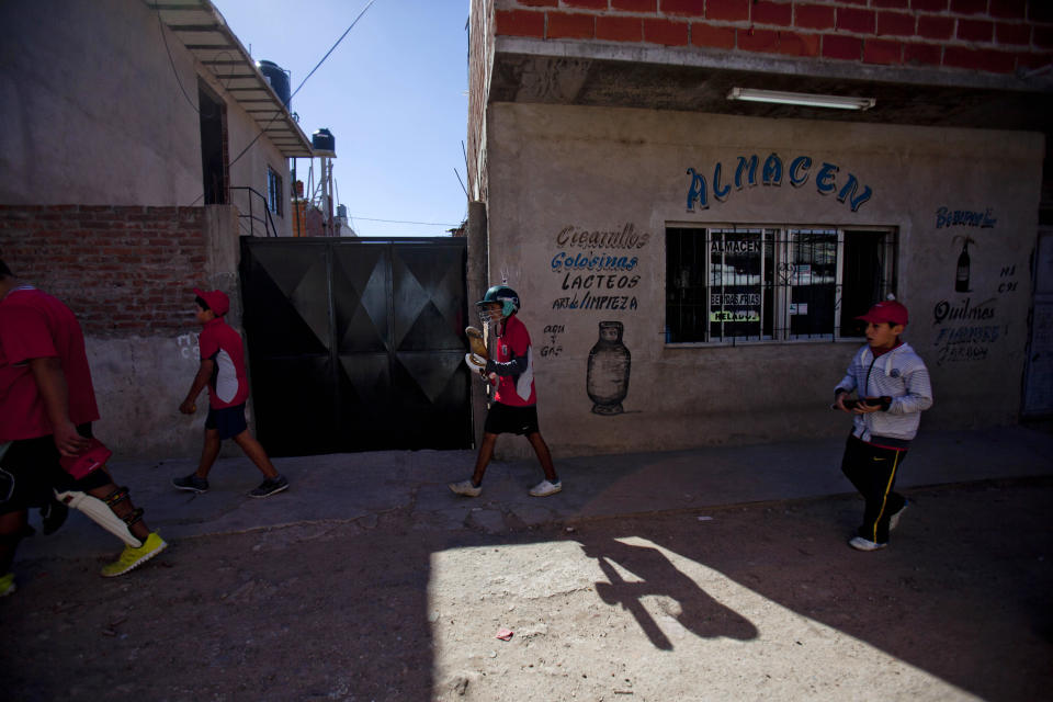 Caacupe cricket team players walk to a training session inside the Villa 21-24 slum in Buenos Aires, Argentina, Saturday, March 22, 2014. The International Cricket Council has recognized the team, formed from the children of the Villa 21-24 shantytown, honoring them as a global example for expanding the sport, which in certain countries, like India, is widely played, but in many parts of the world restricted to elite sectors of society. Introducing cricket in the slum began in 2009 as an idea to transform the game into a social integration mechanism, before that it rarely breached the gates of the country's upscale private schools. (AP Photo/Natacha Pisarenko)