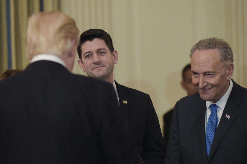 President Donald Trump, left, talks with House Speaker Paul Ryan of Wis., center, and Senate Minority Leader Charles Schumer of N.Y., right, during a reception for House and Senate leaders in the the State Dining Room of the White House in Washington, Monday, Jan. 23, 2017. (AP Photo/Susan Walsh)