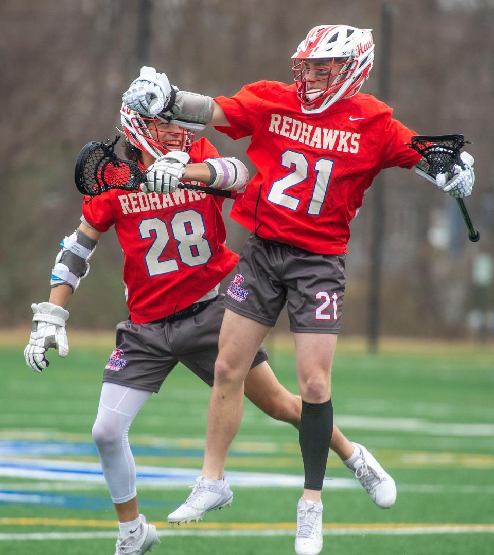 Natick High School sophomore Levi Gagnon, #21, celebrates the first goal of the game against Framingham with junior Donnie Guglielmucci at Fuller Field, April 11, 2024.