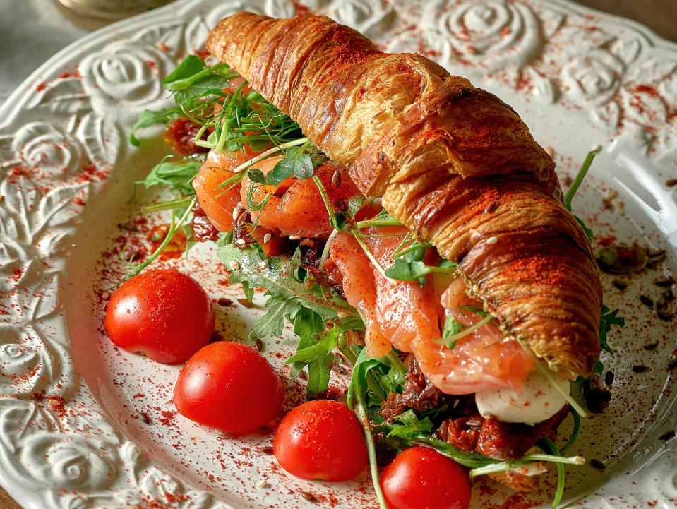 salmon and arugula on a croissant with cherry tomatoes, croissant sandwich