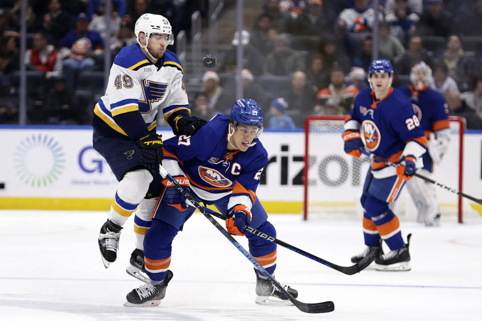 New York Islanders left wing Anders Lee (27) clears the puck in front of St. Louis Blues center Ivan Barbashev during the second period of an NHL hockey game Tuesday, Dec. 6, 2022, in Elmont, N.Y. (AP Photo/Adam Hunger)