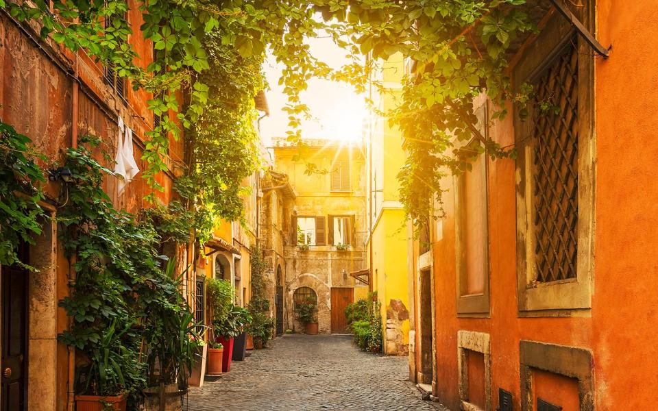 Trastevere is a vine-clad haven of gently winding alleys dotted with artists' stalls - Credit: ALAMY