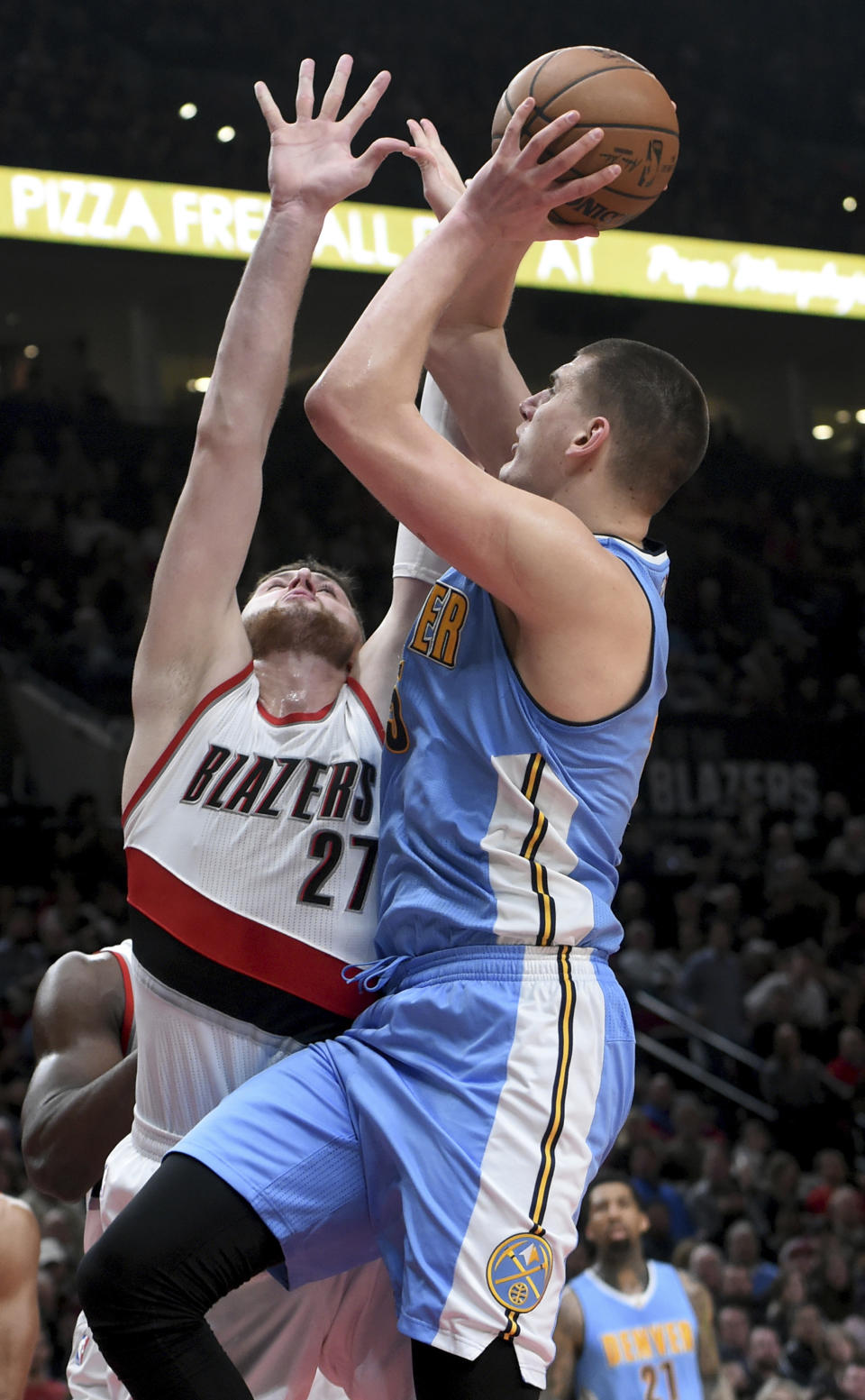 Denver Nuggets forward Nikola Jokic drives to the basket on Portland Trail Blazers center Jusuf Nurkic during the first half of an NBA basketball game in Portland, Ore., Tuesday, March 28, 2017. (AP Photo/Steve Dykes)