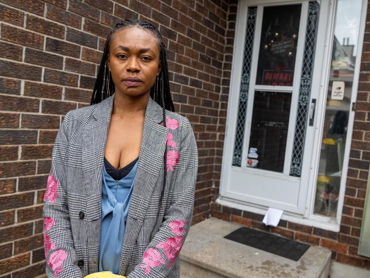 Elsie Kalu stands near the front door of the townhome she bought in April 2022. She says she hasn't been able to move in because the tenant who was living there refuses to leave. (Francis Ferland/CBC - image credit)