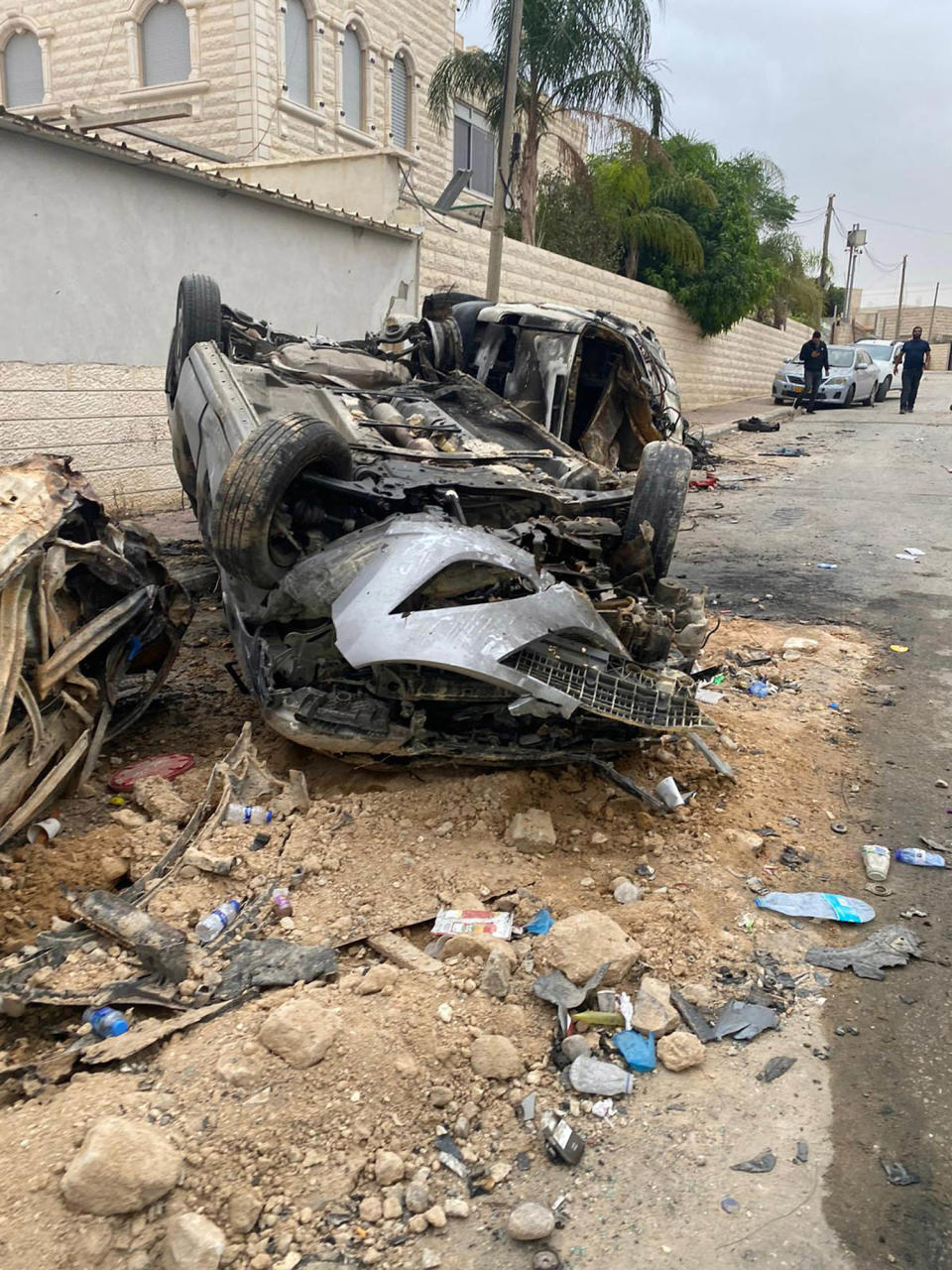 A destroyed car sits in the street from rocket damage in the Bedouin town of Arara. (Courtesy Jawad Abu Asa)