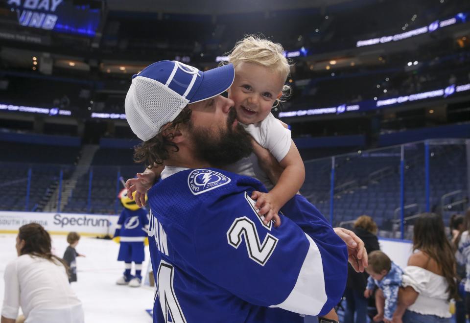 Tampa Bay Lightning's Zach Bogosian holds his son Hunter during an event at Amalie Arena, Tuesday, Sept. 29, 2020, in Tampa, Fla. The Lightning defeated the Dallas Stars the day before to win the NHL hockey Stanley Cup. (Dirk Shadd/Tampa Bay Times via AP)