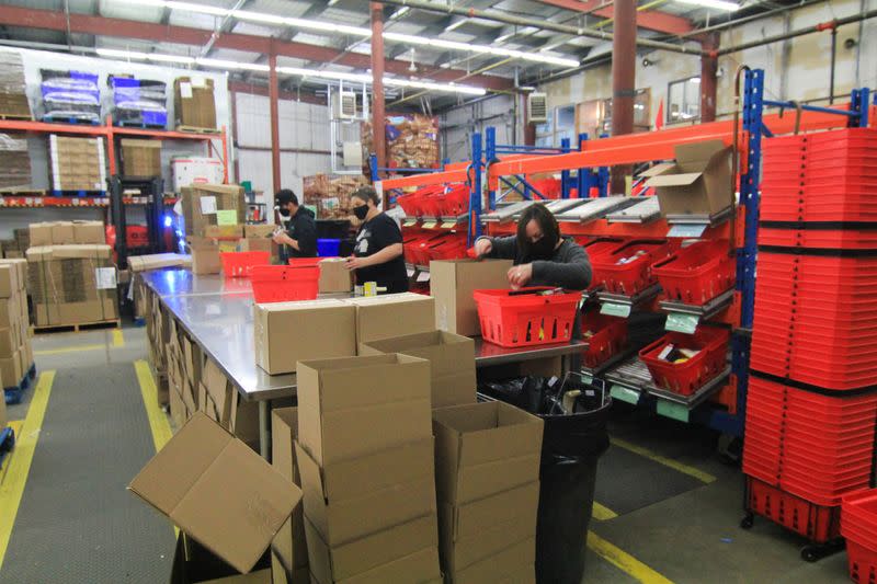 Volunteers fill boxes with donated food at the Ottawa Food Bank warehouse in Ottawa