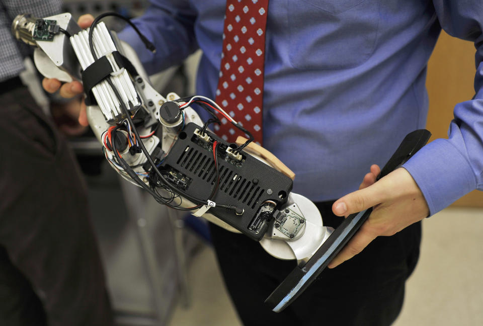 In this Oct. 25, 2012 photo, Dr. Levi Hargrove, lead researcher for the Rehabilitation Institute of Chicago's Center for Bionic Medicine, holds an experimental "bionic" prosthetic leg at the institute. Zac Vawter, a 31-year-old software engineer who lost his right leg in a motorcycle accident, will help test the trailblazing prosthetic leg, that's controlled by his thoughts, when he attempts to climb 103 flights of stairs to the top of Chicago's Willis Tower on Sunday, Nov. 4. (AP Photo/Brian Kersey)