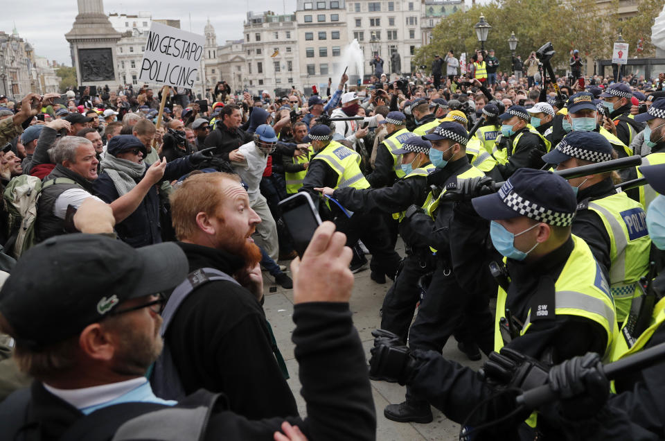 Agentes de la policía metropolitana de Londres chocan con manifestantes durante una protesta contra las restricciones implementadas por el coronavirus, en la Plaza de Trafalgar, el sábado 26 de septiembre de 2020. (AP Foto/Frank Augstein)