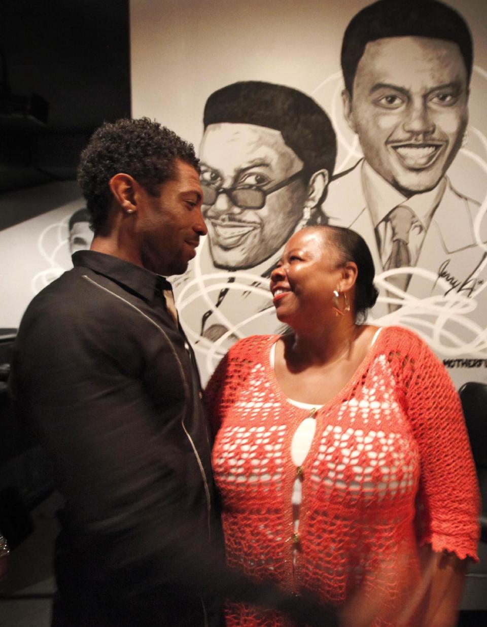 In this June 8, 2012 photo, Mary Lindsey, right, owner if the Jokes and Notes comedy club thanks comedian and writer Deon Cole for performing two shows, in front of the club's tribute to Bernie Mack, in Chicago's Bronzeville neighborhood. African-American female club owners are a rarity in the industry of comedy, but Lindsey is breaking barriers and uplifting a community by providing a place where raw comedic talent can hone their skills. (AP Photo/Charles Rex Arbogast)